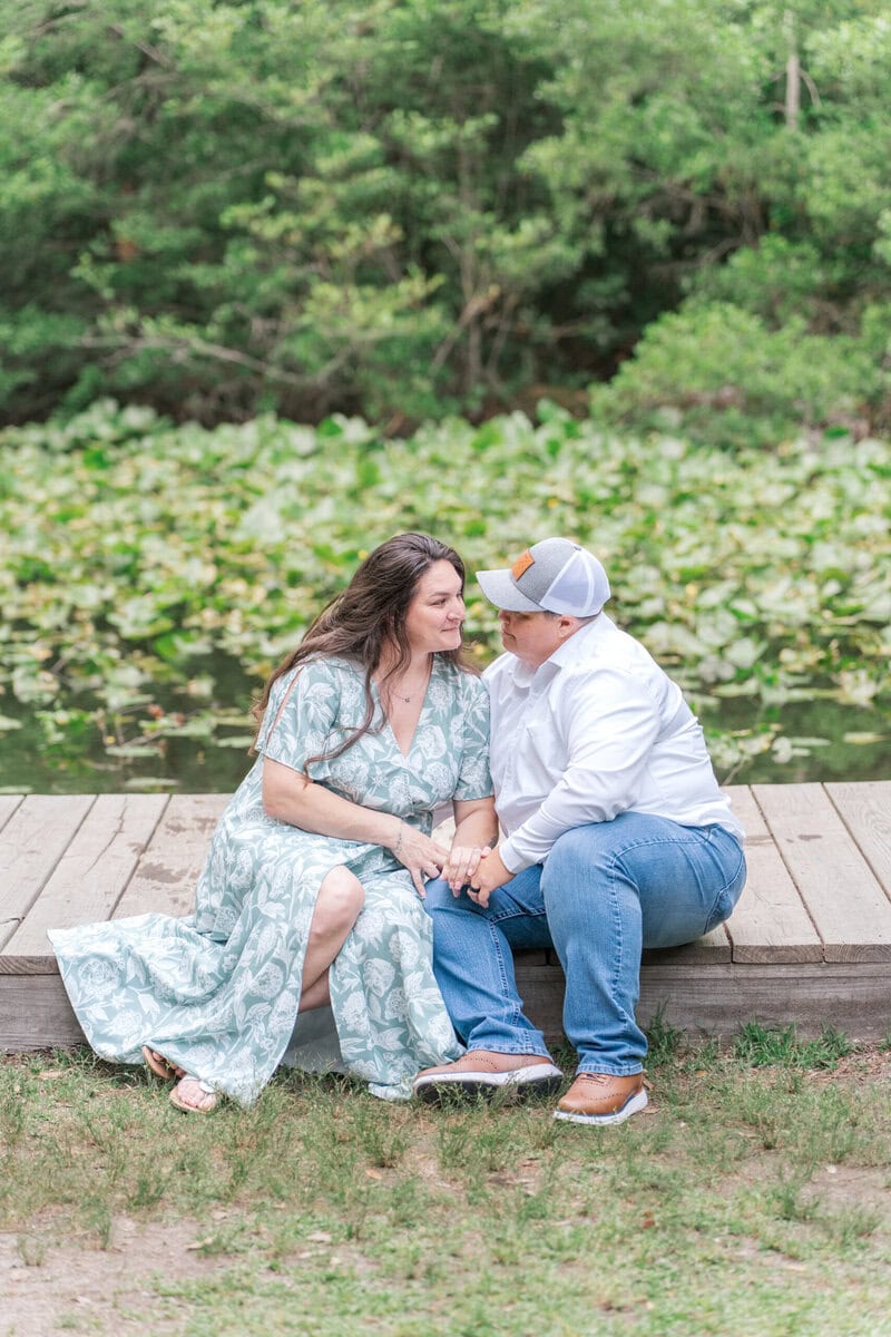 Portrait of the couple near the pond reflecting the surrounding trees