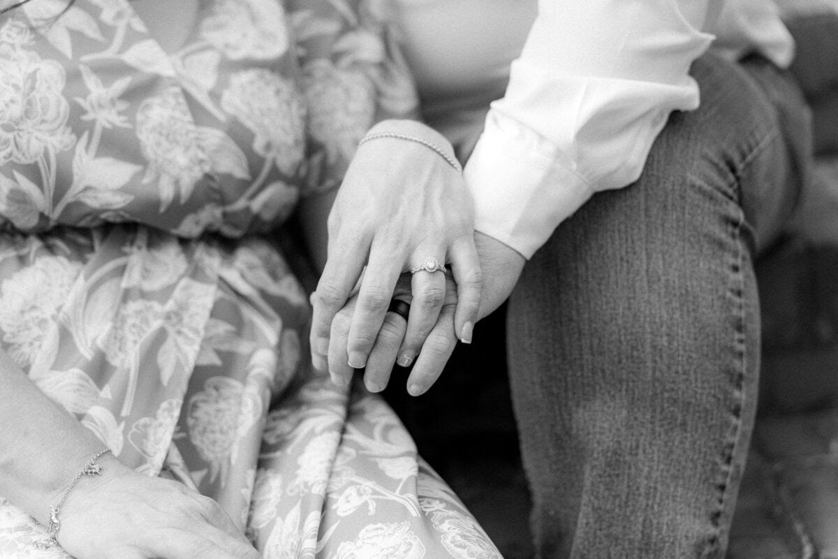 Detail shot of the couple's hands together framed by garden greenery