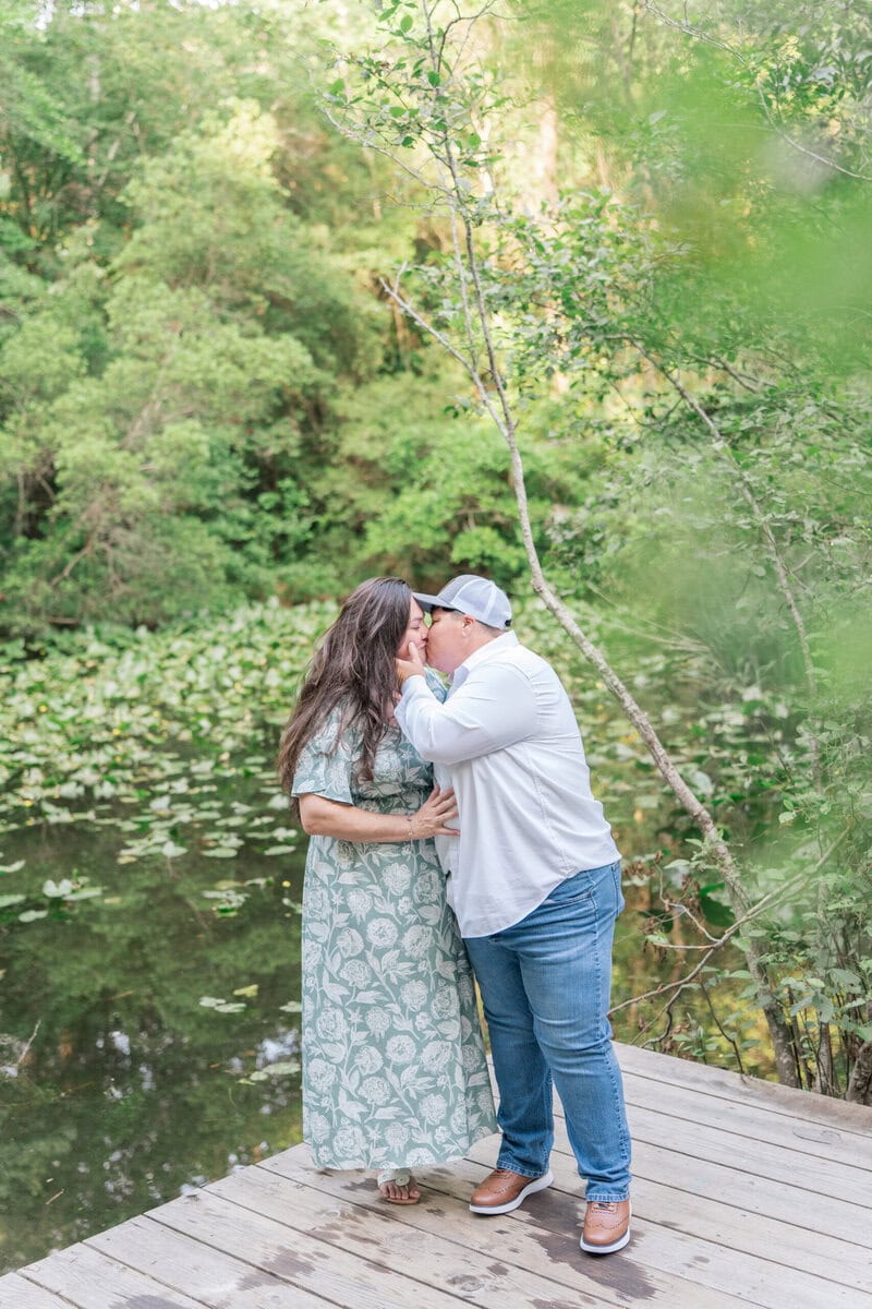 Nikki and Ashley embracing at the edge of the pond in warm golden light