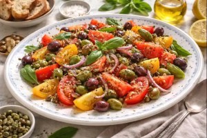 Tomato caper olive salad served as a bright Mediterranean starter with fresh herbs