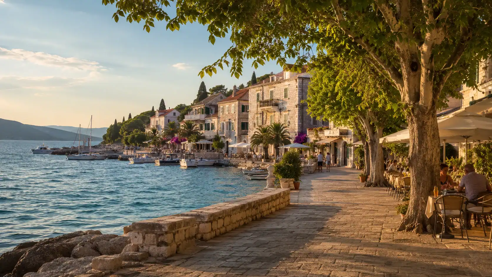 A shaded Mediterranean harbor town in August with the sea nearby and people walking in the evening