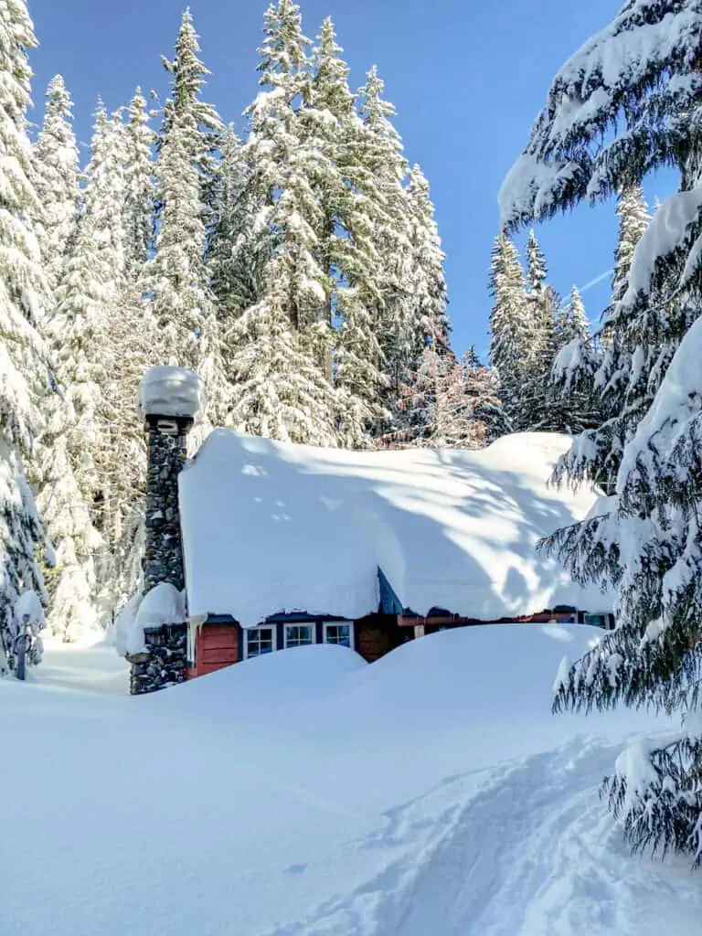 cabin half buried in the snow.