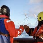 fishermen bumping fists in the deck of a trawler