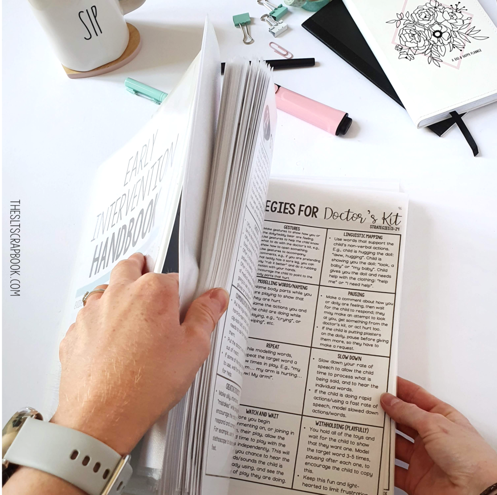 Picture of the Early Intervention Handbook partially open on a white desk, with office stationary arranged nearby. The Early Intervention Handbook is open on the 'Strategies for Doctor's Kit' page, giving ideas for explaining early language strategies in your parent coaching sessions.