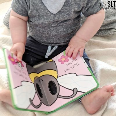 Picture of a child holding 'That's not my bee' book and turning the pages, so you can target turn-taking skills with these books.