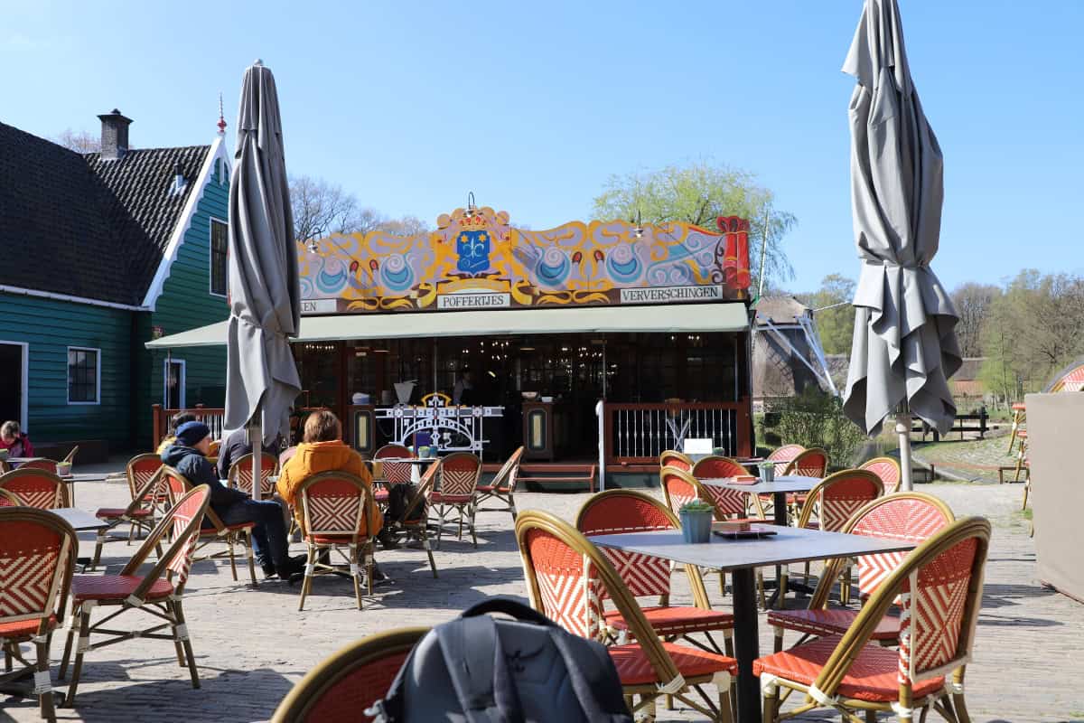 Colourful outdoor café at The Wandering Woodward with vintage-style seating and umbrellas, perfect for relaxing in the sun.