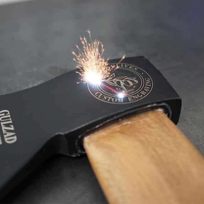 Engraving tool creating custom design on wood surface.