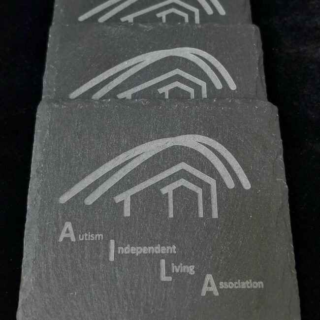 Hand engraved Autism Awareness logo on black slate stone.