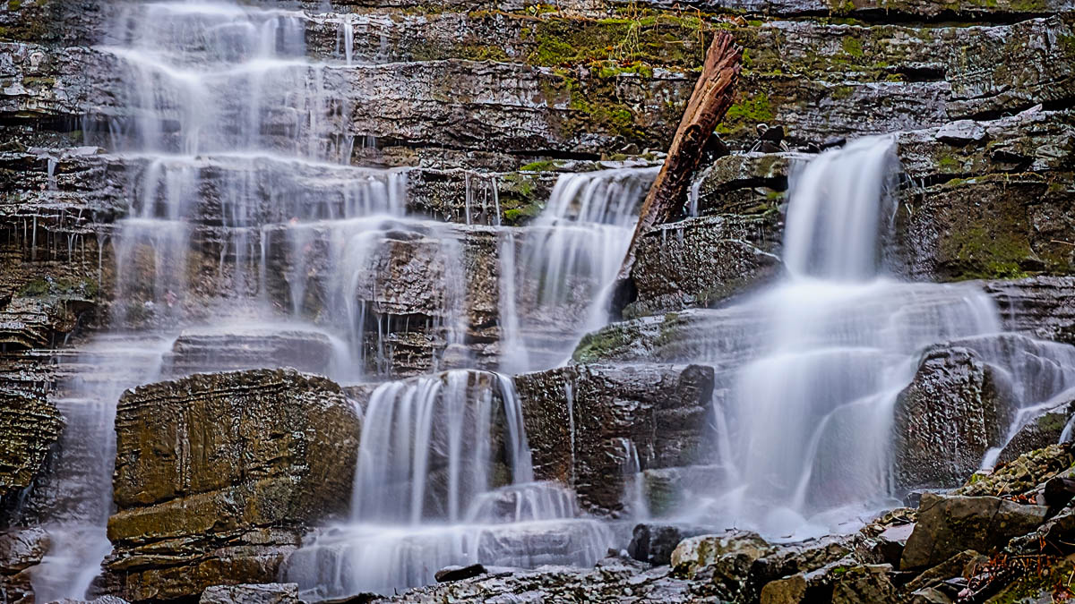The wavy bedding planes in the rock funnel the water down and across the face of this waterfall.