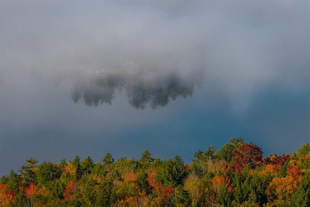 view of lake fog around an island in fourth lake from rocky mountain, inlet, new york