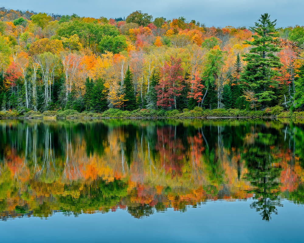 Adirondack peak fall foliage with a reflection on the lake