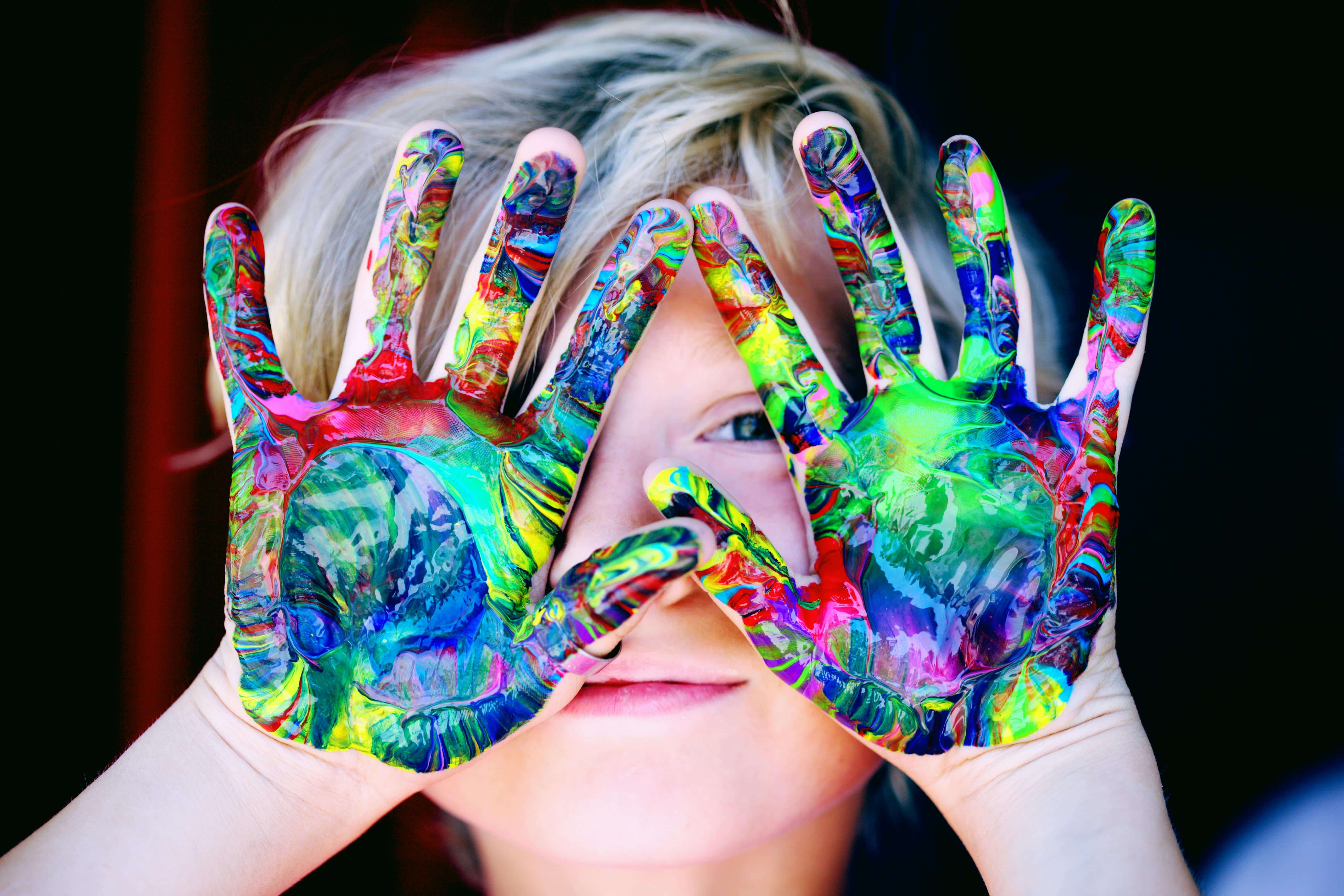 Traveling with Special Needs Kids – Joyful Expression Child with colorful painted hands traveling with special needs kids