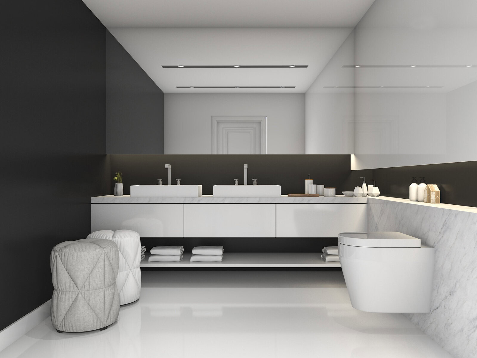 Modern bathroom with double sinks, two ottomans, and a toilet.