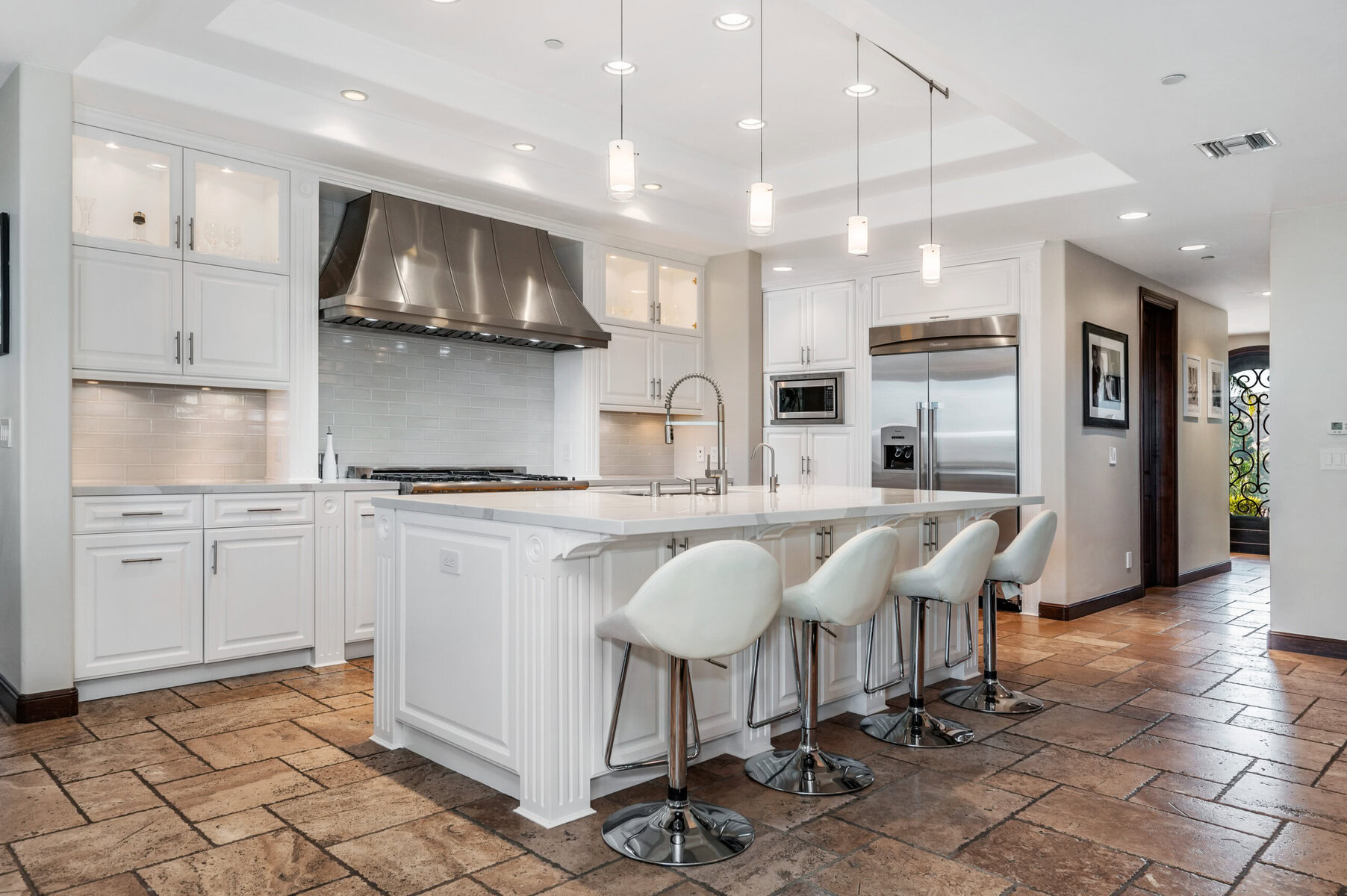 Modern white kitchen with large island and stainless steel appliances
