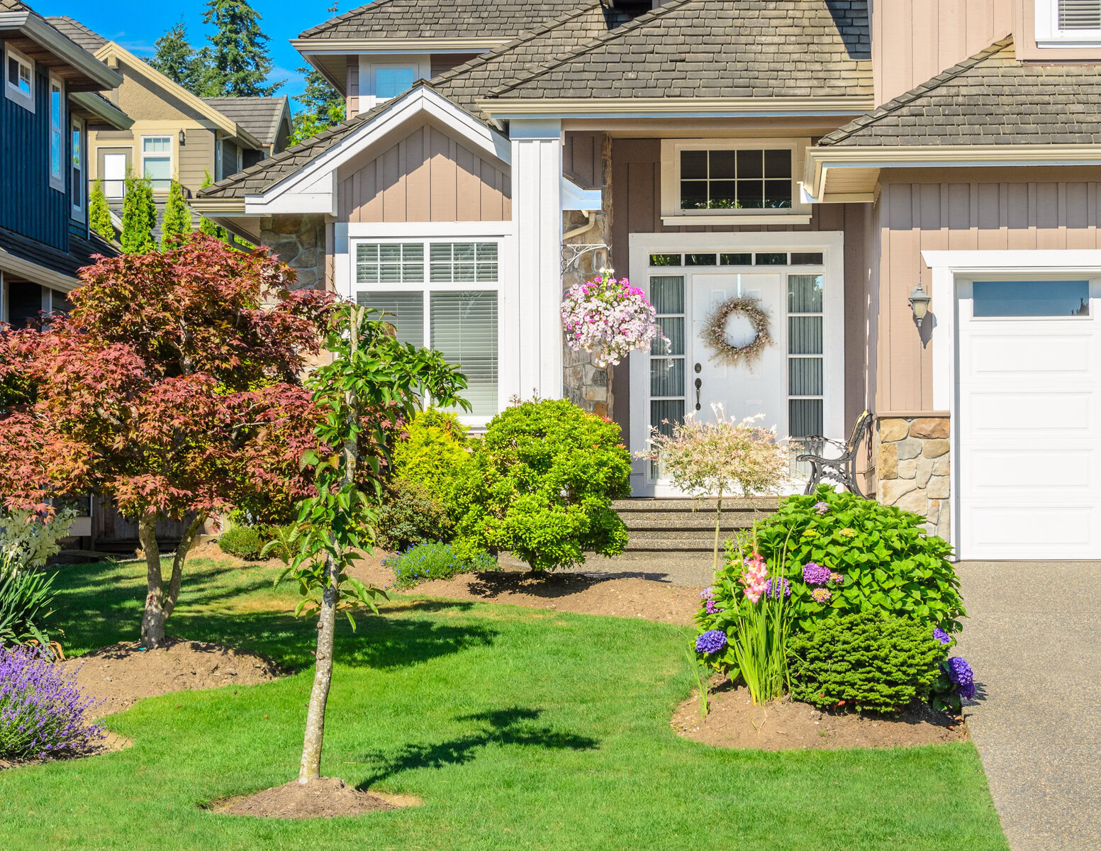 Front exterior of a two-story house with a white door and green lawn.