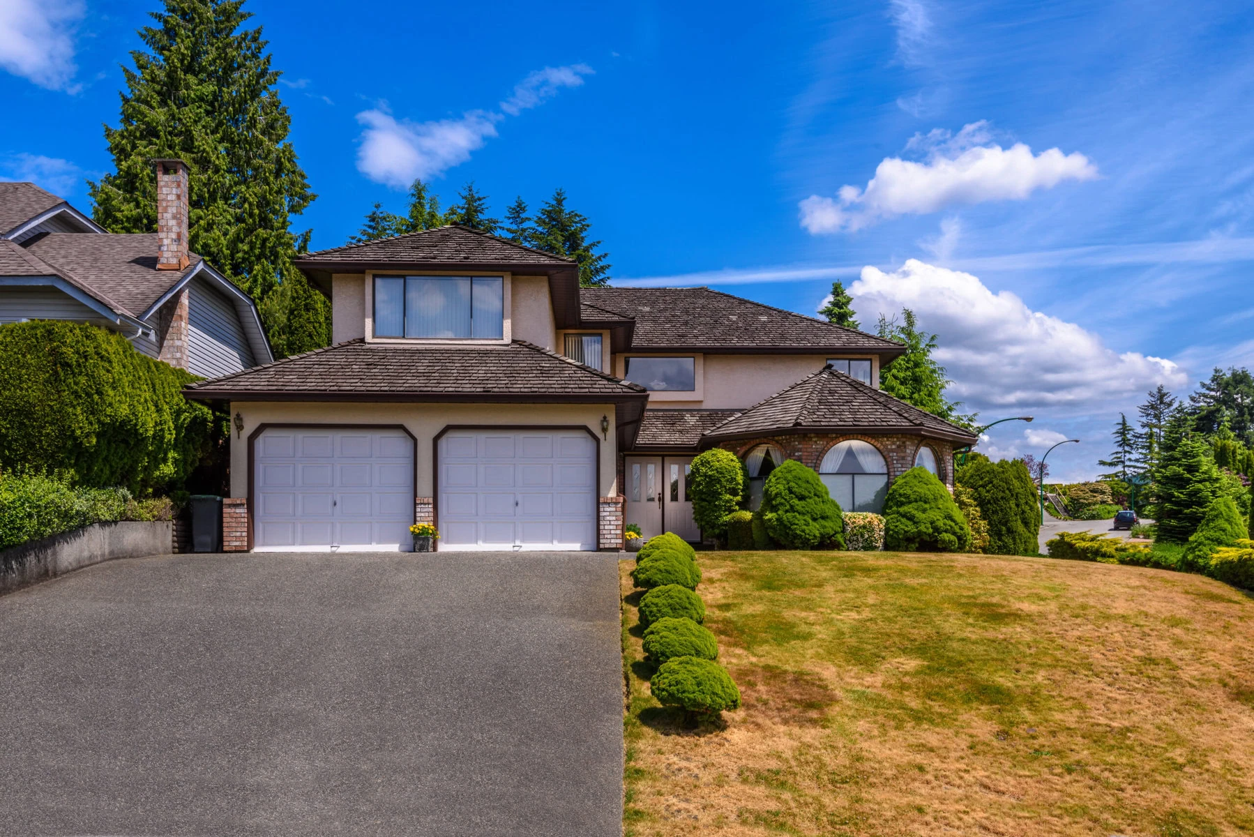 Large two-story house with a double garage and green landscaping