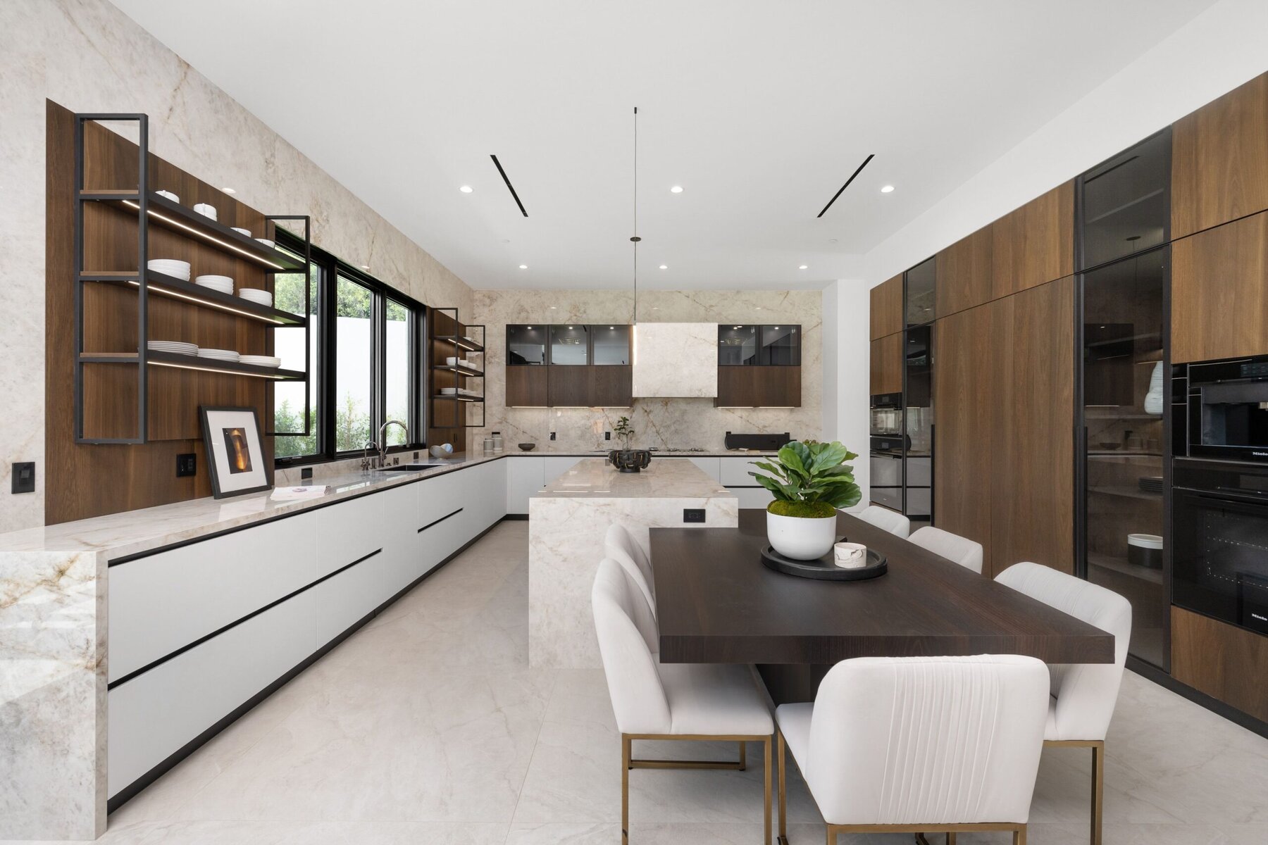 Modern kitchen with marble countertops, dark wood cabinets, and dining area