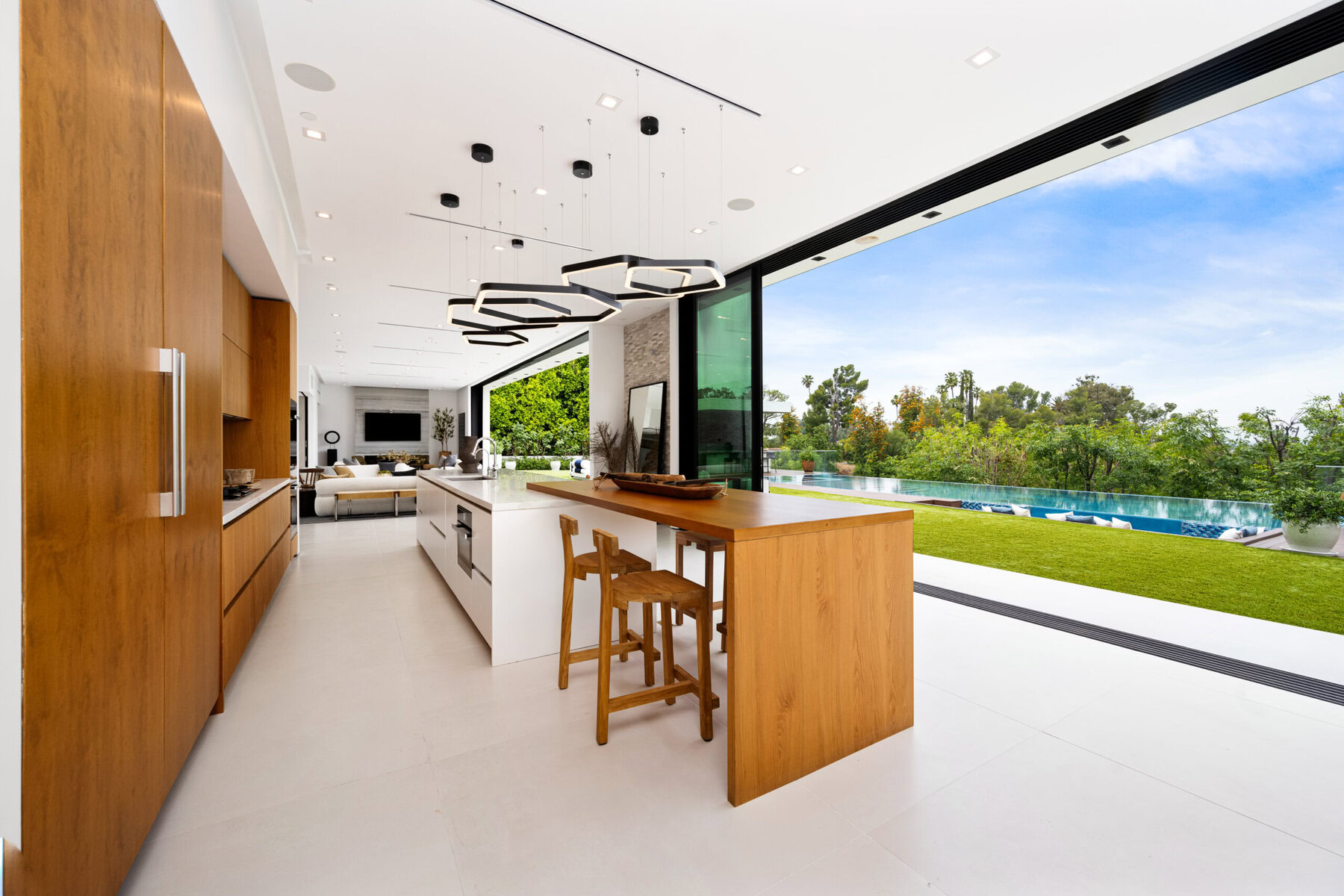 Modern kitchen with wooden cabinets, white island, and outdoor view.
