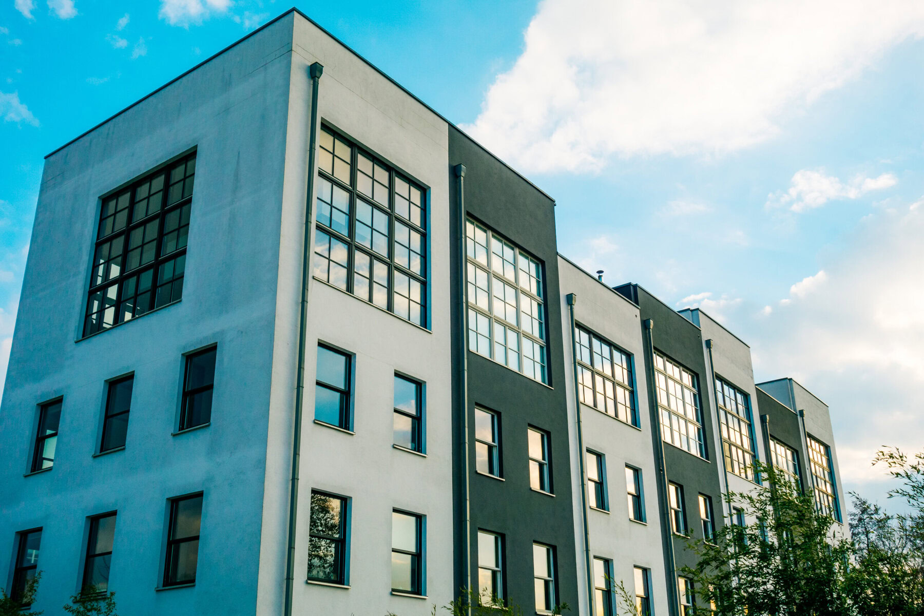 Modern building with light and dark facades under a blue sky