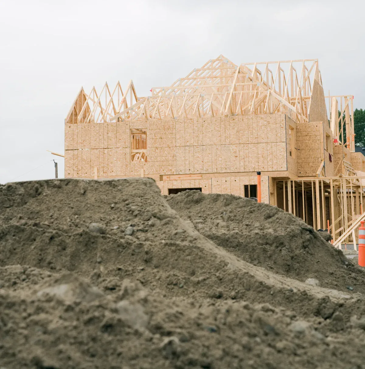 New house under construction with visible wooden framing and plywood sheathing