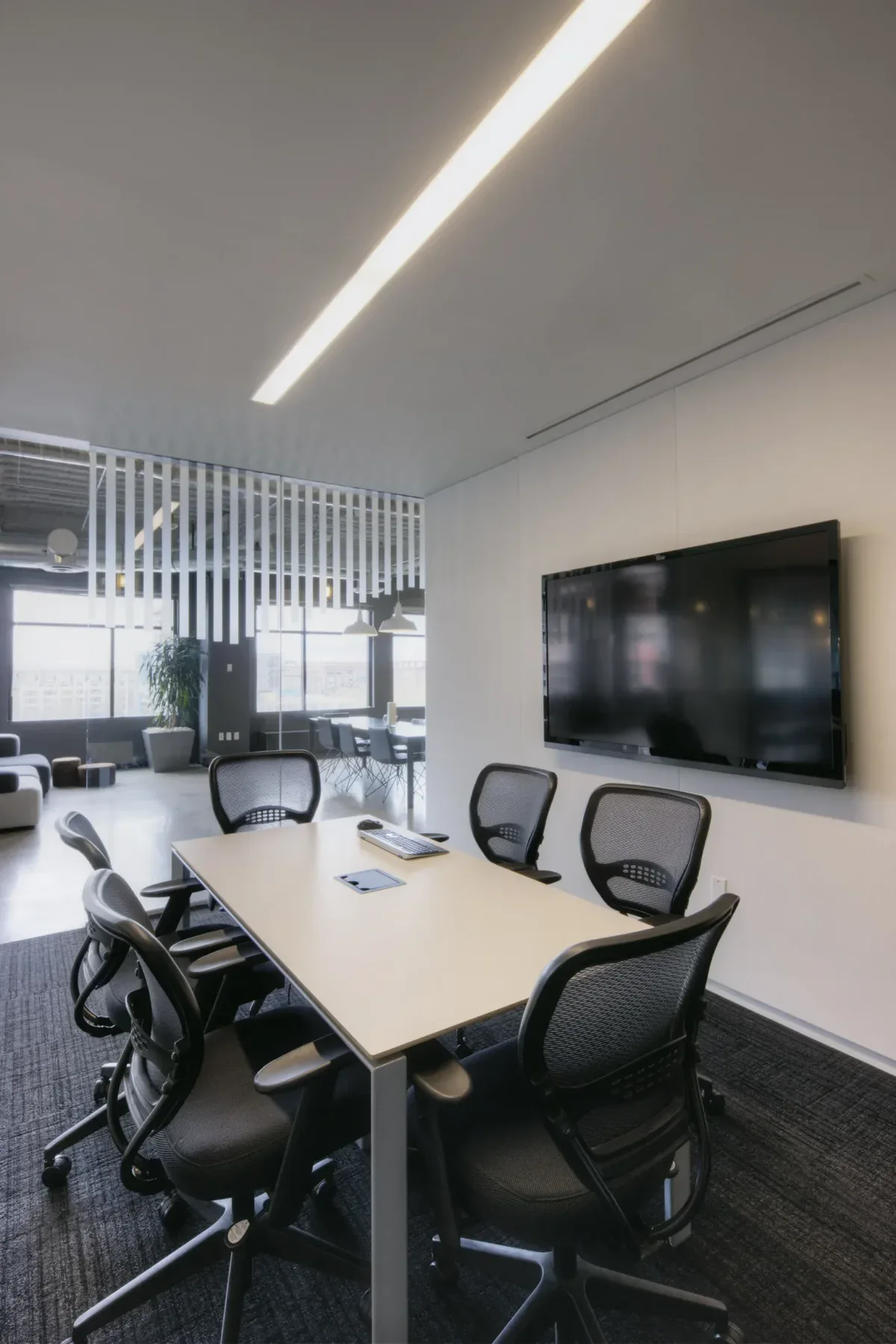 Modern meeting room with a large screen and office chairs