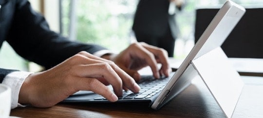 man typing on a keyboard connected to an ipad