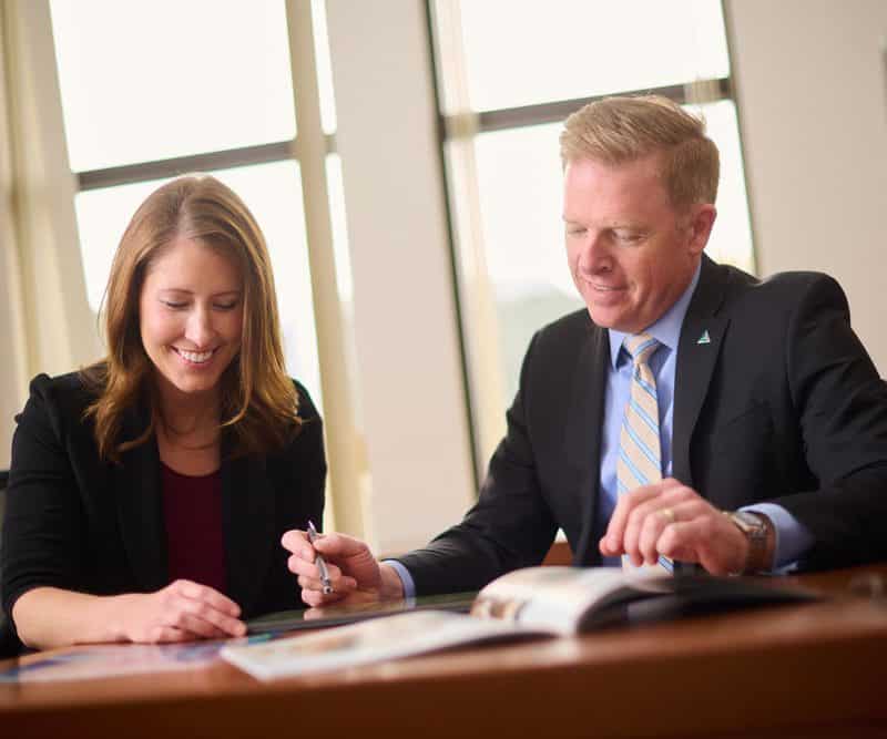 2 business people talking while reviewing documents