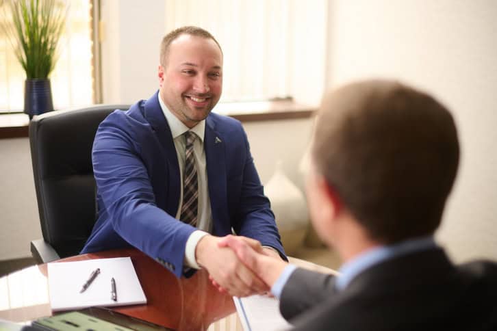business people shaking hands over table