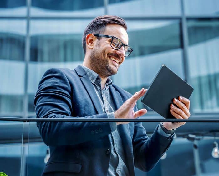 man using tablet while standing outside