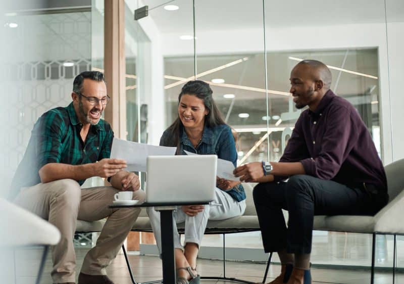 3 people meeting with laptop and paper documents