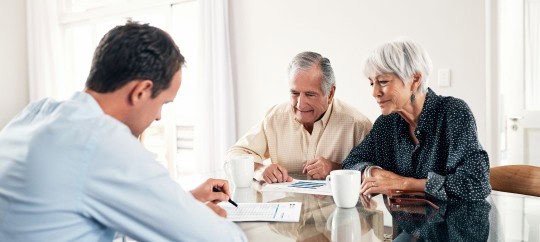 Retired couple talking to financial professional about investing