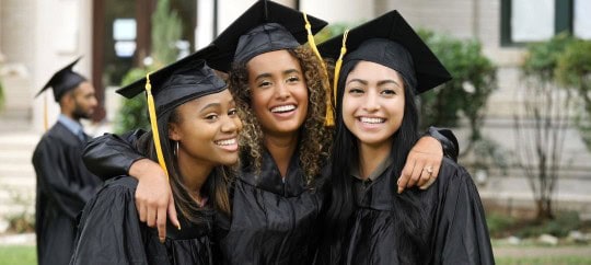 3 college graduate girls smiling