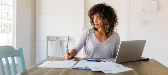 Women writing on financial documents