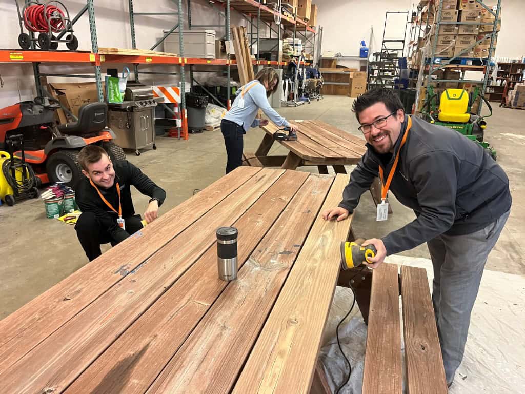 Trust Point Young Professionals Sanding Picnic tables at Aptiv
