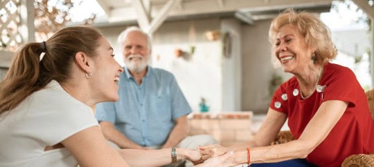 Woman talking to her adult parents while smiling
