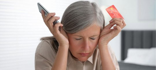 Women holding a credit card upset after being scammed