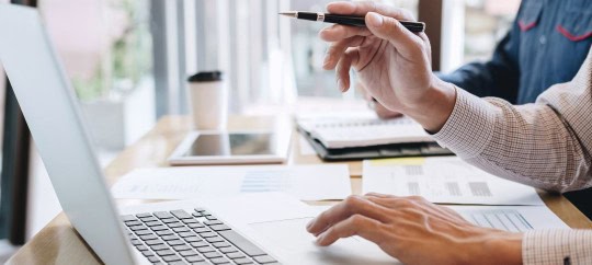 Businessman pointing to Investment Policy Statement on a laptop screen