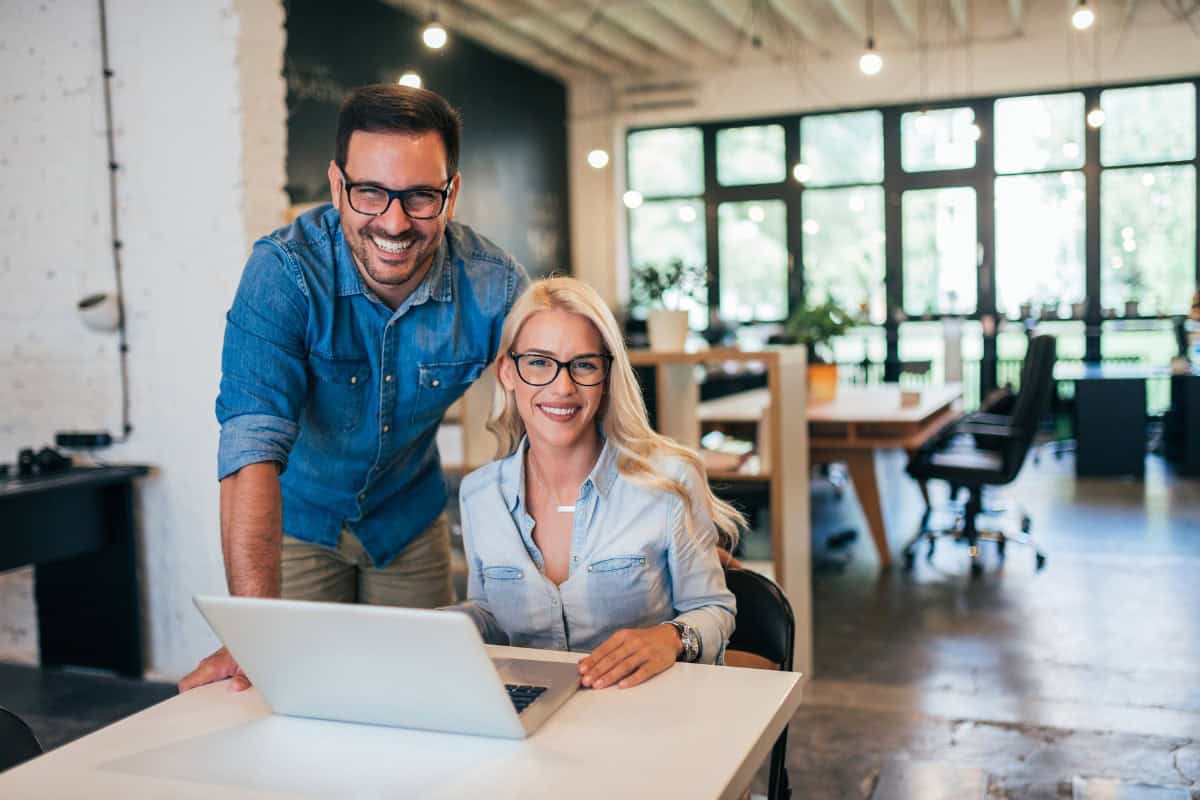 Two Business Professionals Planning with Laptop Smiling