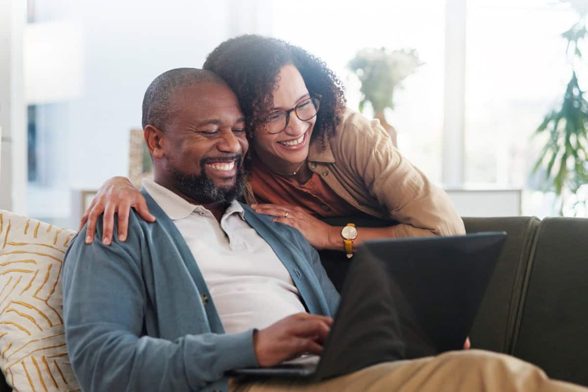 Mature Couple Looking At Laptop Together Smiling