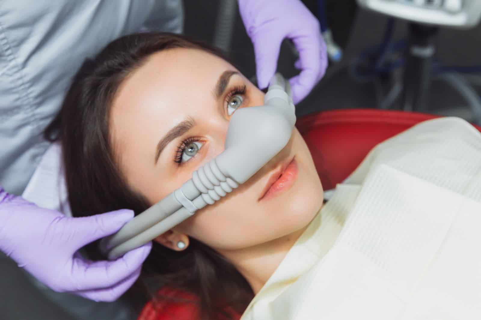 Dentist puts inhalation sedative mask on his patient