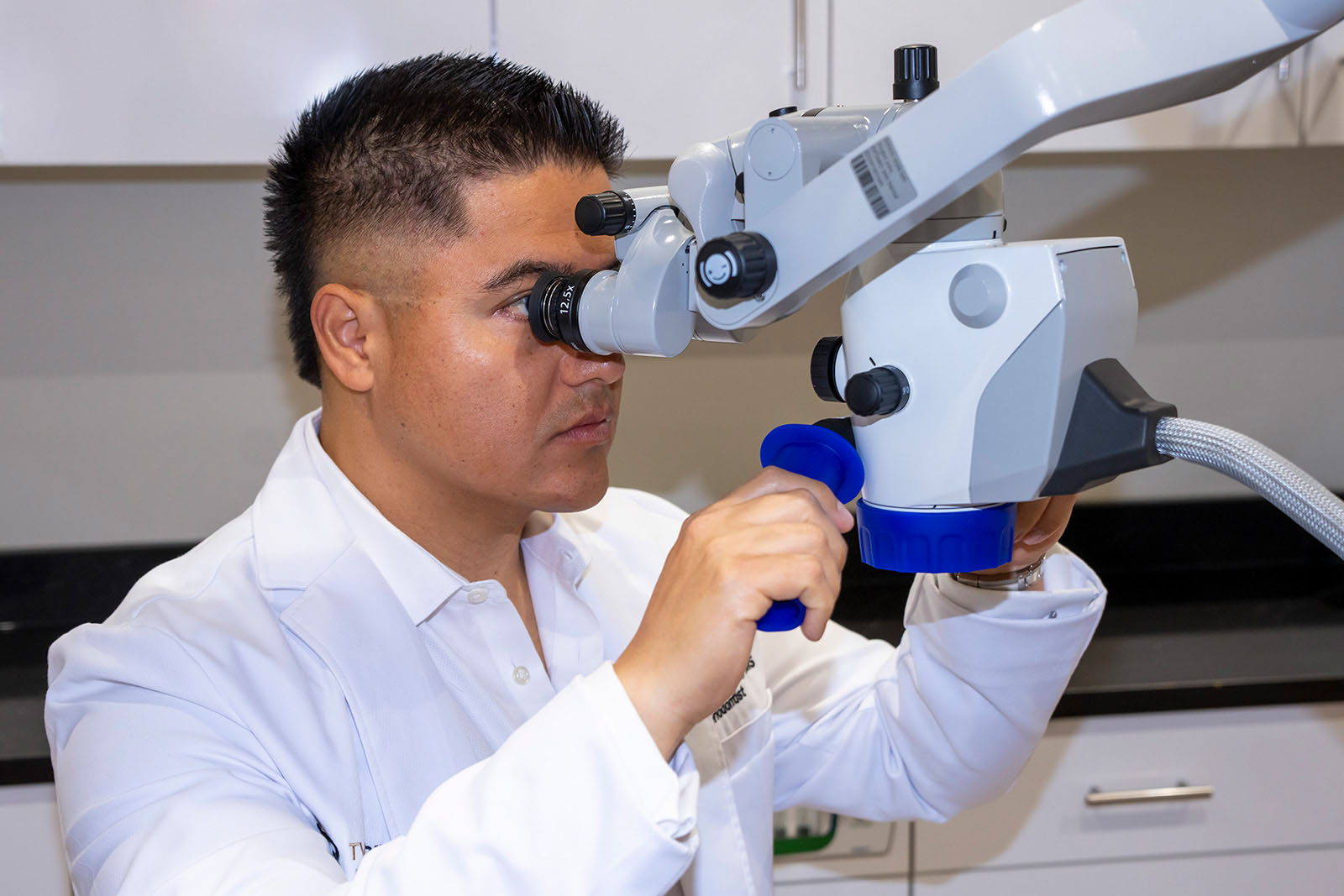 Dr. Molina examining through a dental microscopic device