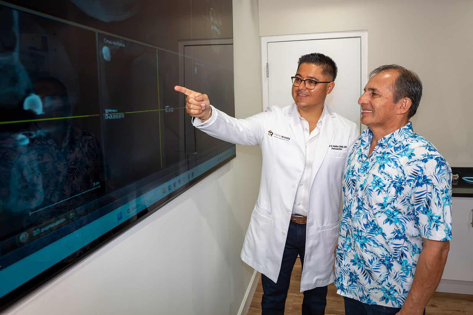 Dr. Molina showing a patient an X-ray on a screen