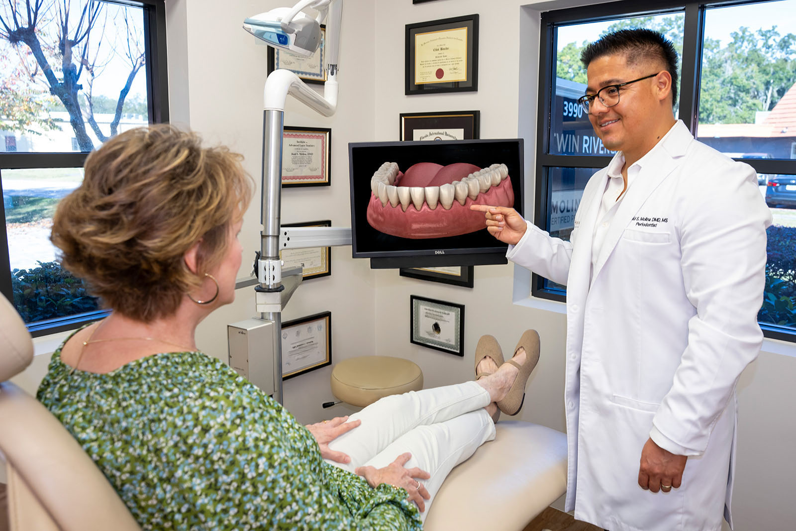 Dr. Molina showing a patient about recession gum treatment