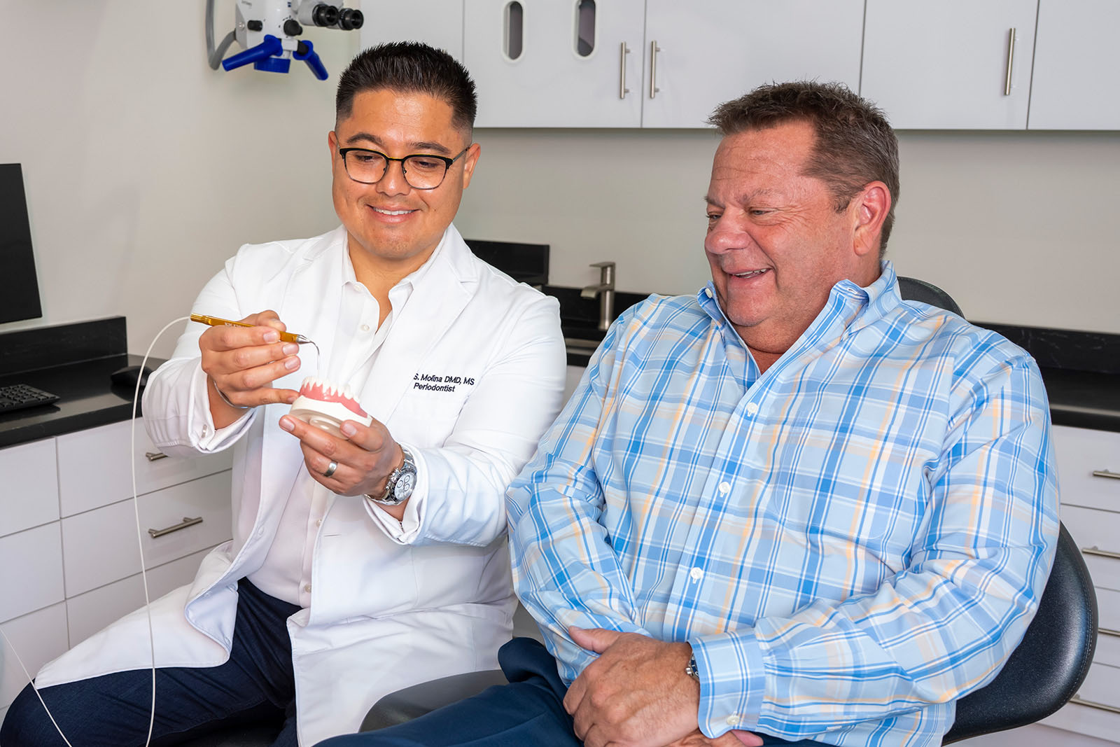 Dr. Molina shows a patient a teeth model
