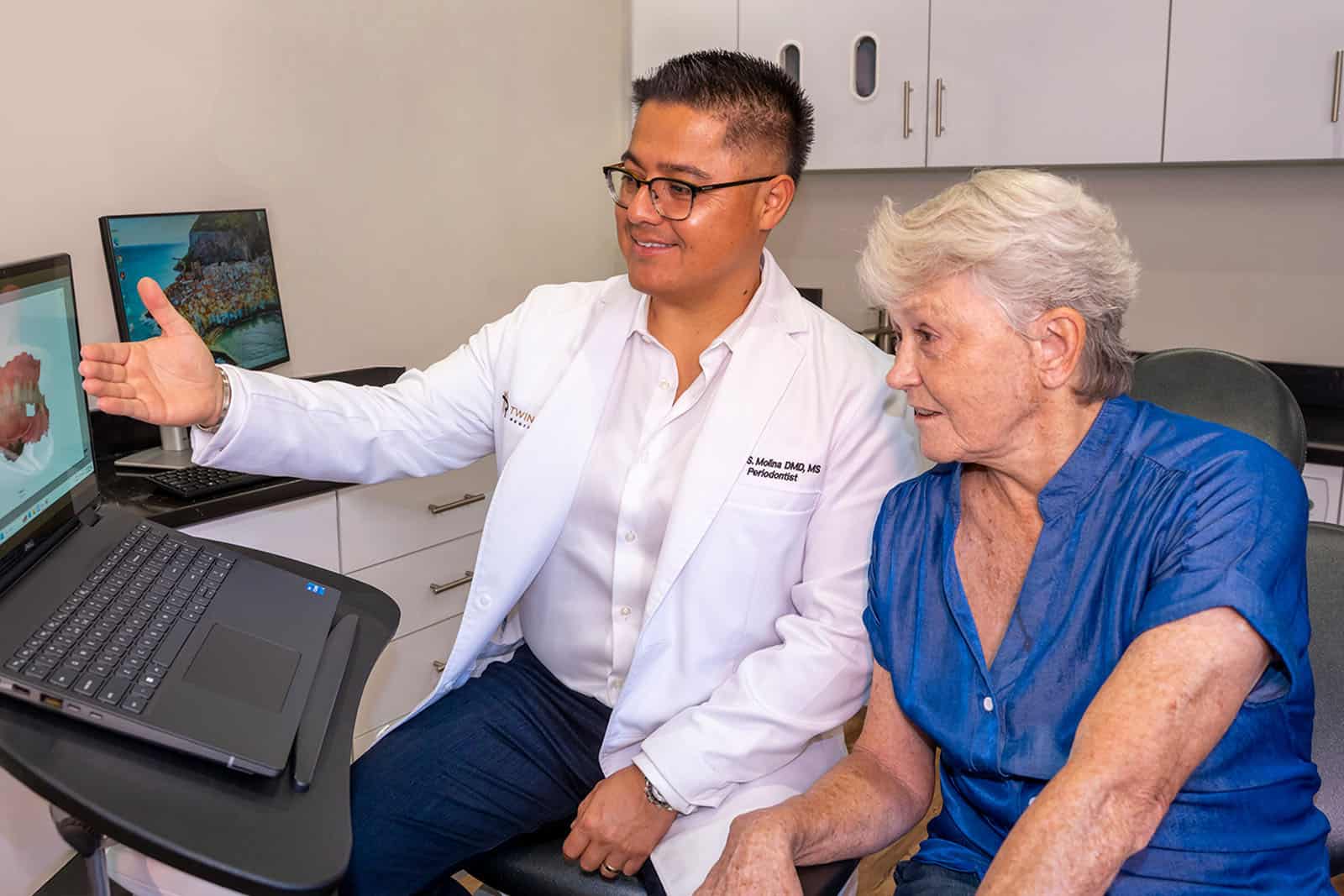 Dr. Molina showing a patient a 3D teeth model on a screen