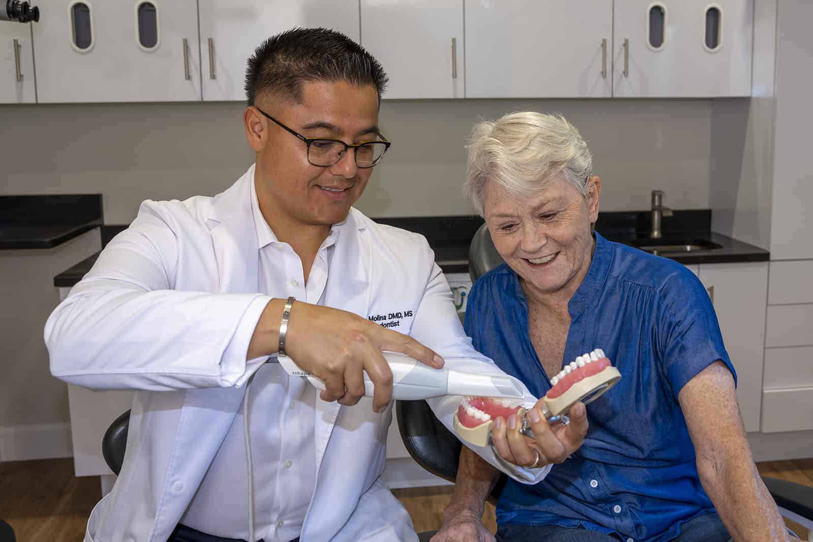 Dr. Molina showing a patient how a digital impression scanner works
