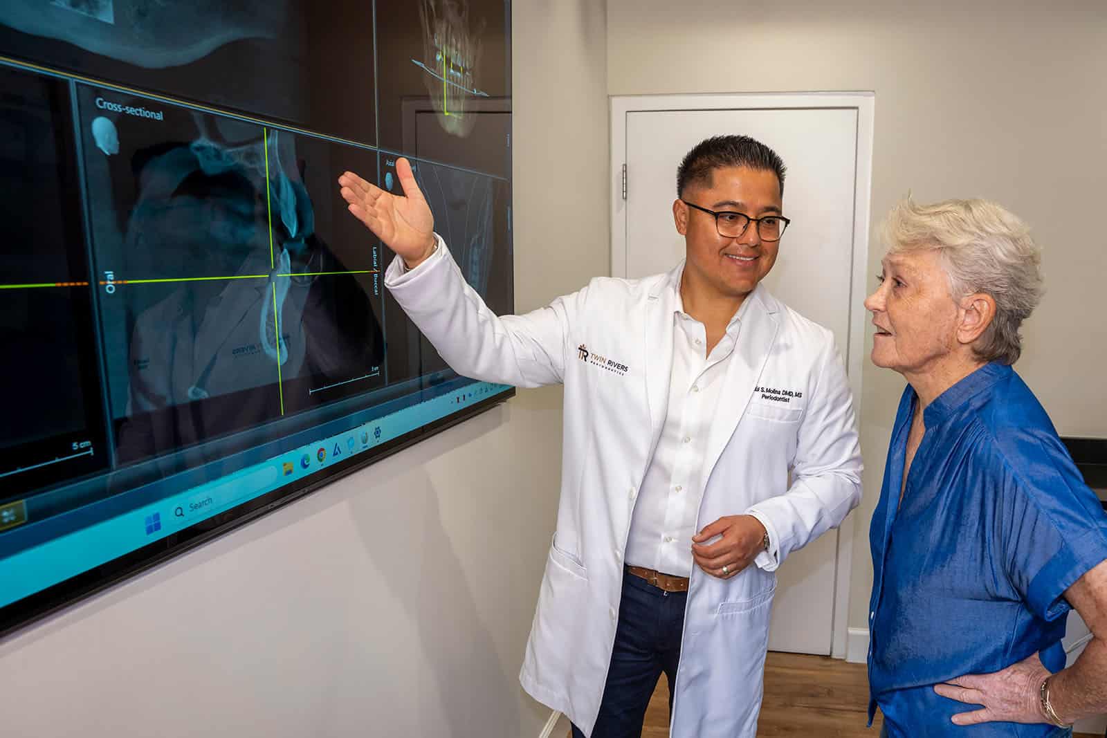 Dr. Molina shows a patient implant X-rays on a screen