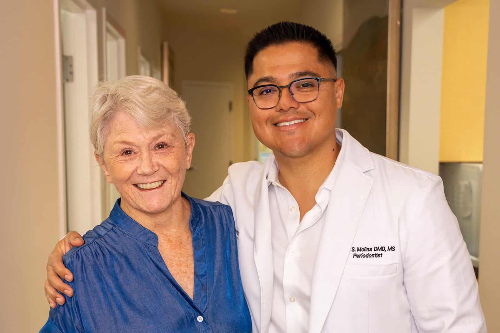 Dr. Molina smiling with a patient after an implant treatment