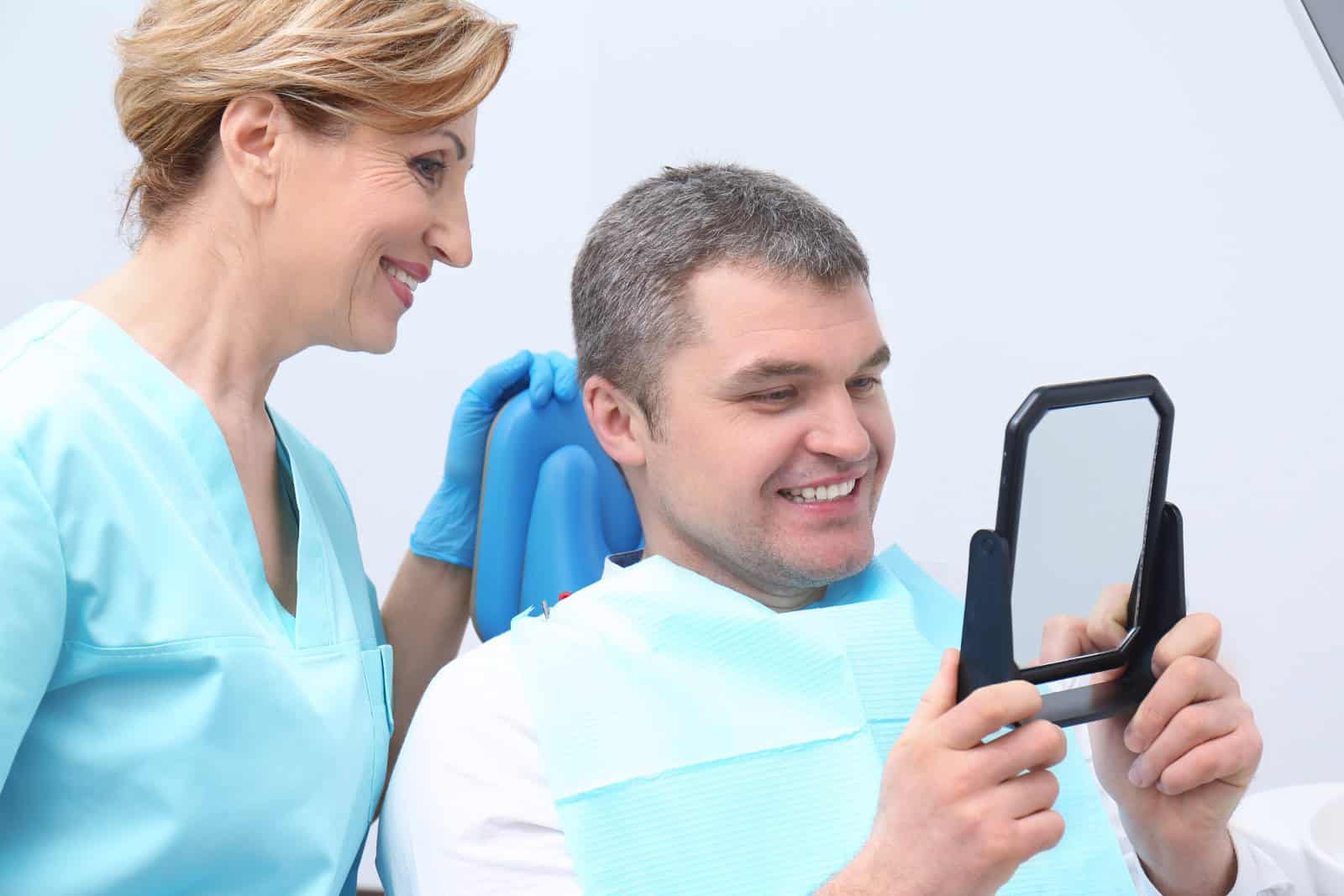 Man checking result of dental treatment
