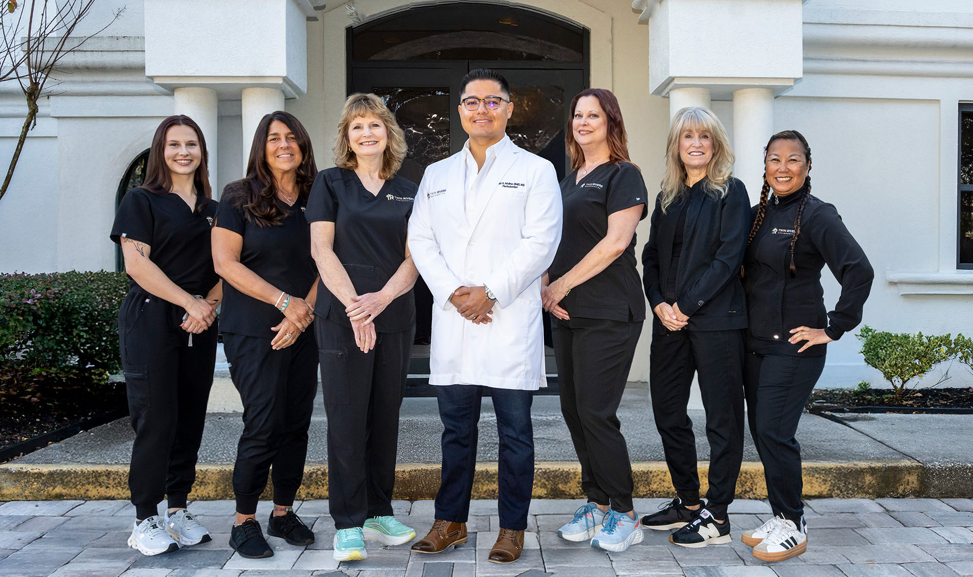 Medical team posing outside building.